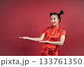 Friendly Chinese female gesturing to side for Lunar New Year advertisement Friendly Chinese female gesturing to side for Lunar New Year advertisement 133761350