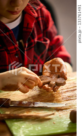 Girl sculpting clay gingerbread figure with focus Girl sculpting clay gingerbread figure with focus 133761491