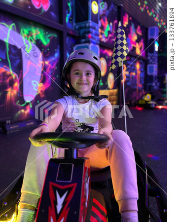 Smiling girl enjoying racing game in arcade 133761894