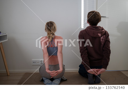 couple stretching together on yoga mats at home during morning workout 133762540