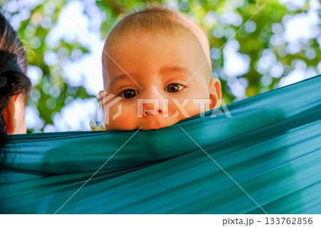 Baby Peeking Over Turquoise Fabric Outdoors 133762856