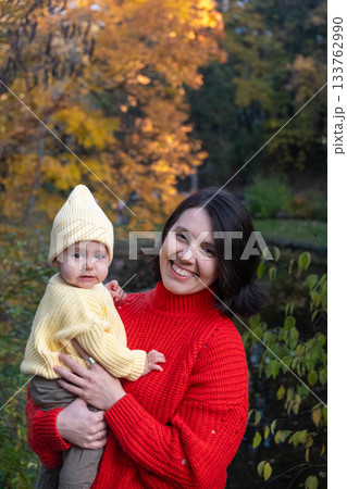 Mother and Baby Smiling in Autumn Park Mother and Baby Smiling in Autumn Park 133762990