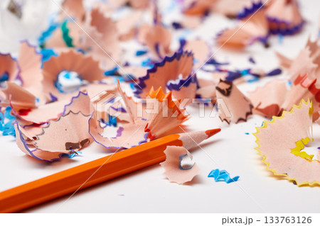 Orange pencil tip surrounded by colorful wood shavings on a white background Orange pencil tip surrounded by colorful wood shavings on a white background 133763126