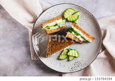 Close up of cucumber sandwich with butter and cream cheese on a plate on the table top view 133764594
