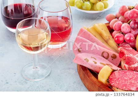 Italian Antipasti with wine glasses and fruit. Charcuterie platter with Bologna 133764834