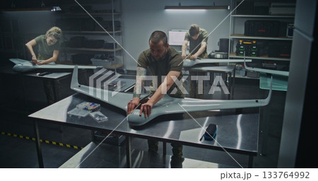 Woman and Men Assembling Advanced Military Drones in Factory Woman and Men Assembling Advanced Military Drones in Factory 133764992