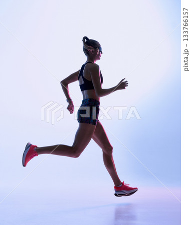 Futuristic female runner mid-stride in soft neon gradient background 133766157