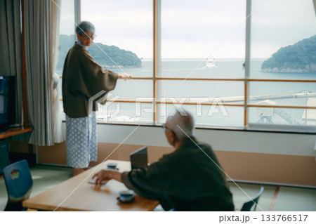 和室で景色を撮影する高齢夫婦の旅館シーン 和室で景色を撮影する高齢夫婦の旅館シーン 133766517