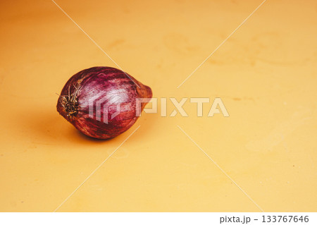 Single red onion on a vibrant orange background 133767646