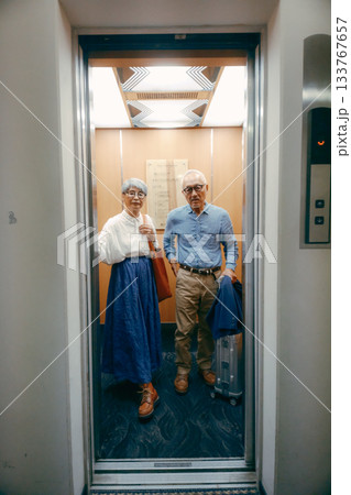 エレベーターに乗るシニア夫婦の旅行シーン エレベーターに乗るシニア夫婦の旅行シーン 133767657