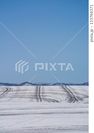 融雪剤が撒かれた雪の畑と山並み 大雪山 融雪剤が撒かれた雪の畑と山並み 大雪山 133768371