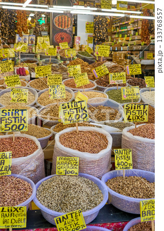 A vibrant display of various nuts and dried goods at a bustling Turkish market, with price tags and labels in Turkish. 133768557