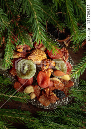 Assorted dried fruits and nuts on a silver tray. 133769843