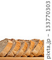Sliced bread loaf on wooden board with white background 133770303