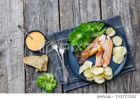 hot smoked trout fillet with lettuce, potato chips 133772582