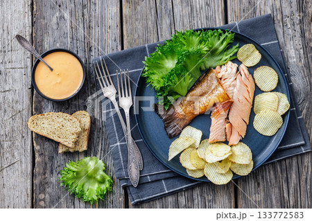 hot smoked trout fillet with lettuce, potato chips hot smoked trout fillet with lettuce, potato chips 133772583