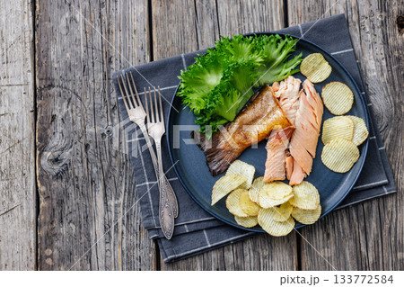 hot smoked trout fillet with lettuce, potato chips 133772584