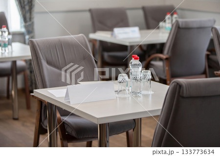 Part of a conference room with empty tables and chairs. Part of a conference room with empty tables and chairs. 133773634