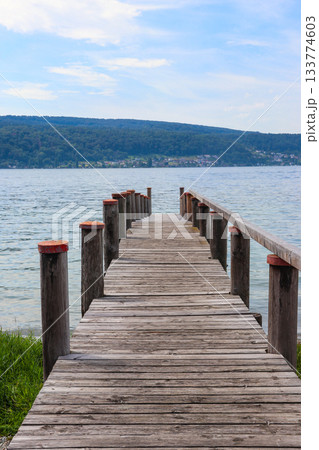 Wooden pier overlooking the Alps and Lake Constance in Switzerland Wooden pier overlooking the Alps and Lake Constance in Switzerland 133774603