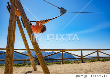 Adult woman having fun on zipline Adult woman having fun on zipline 133774714