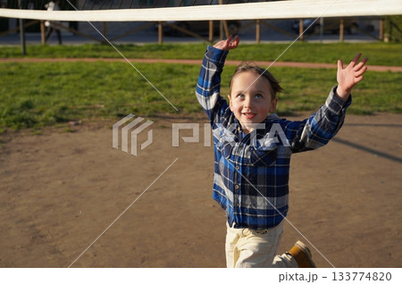 Joyful Child Playing Outdoors Near Sports Net Joyful Child Playing Outdoors Near Sports Net 133774820