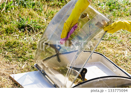 Woman cleaning old caravan sunroof 133775094