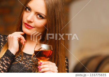 Woman tasting wine in rural cottage interior Woman tasting wine in rural cottage interior 133775635