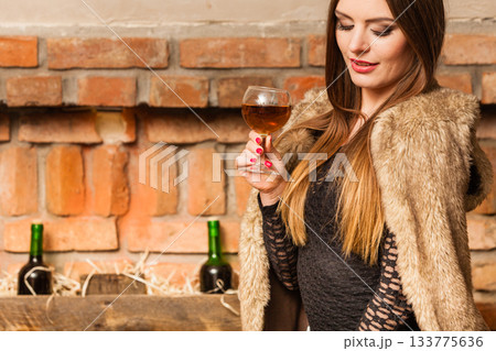 Woman tasting wine in rural cottage interior Woman tasting wine in rural cottage interior 133775636