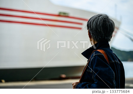 港で大型フェリーを見つめる白髪交じりの男性の後ろ姿 港で大型フェリーを見つめる白髪交じりの男性の後ろ姿 133775684