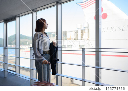 窓から船を見つめる若い女性旅行者、出航を待つ 窓から船を見つめる若い女性旅行者、出航を待つ 133775736