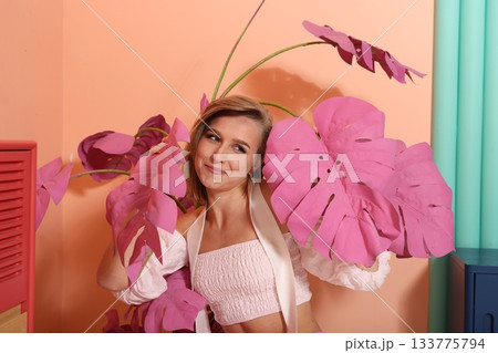 Contemplative female subject amid gentle pink botanical scenery 133775794