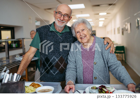 Elderly couple having lunch in community center cafeteria. Elderly couple having lunch in community center cafeteria. 133775926
