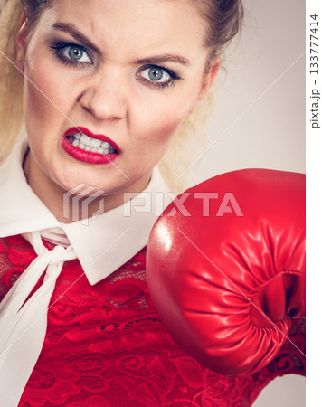 Angry woman wearing boxing gloves Angry woman wearing boxing gloves 133777414