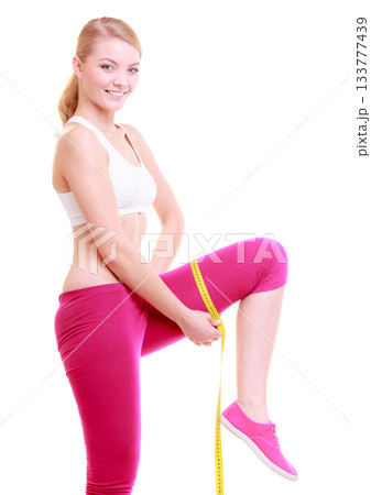 Fitness woman fit girl with measure tape measuring her thigh Fitness woman fit girl with measure tape measuring her thigh 133777439