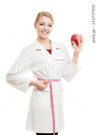 Doctor specialist holding fruit apple measuring waist Doctor specialist holding fruit apple measuring waist 133777455
