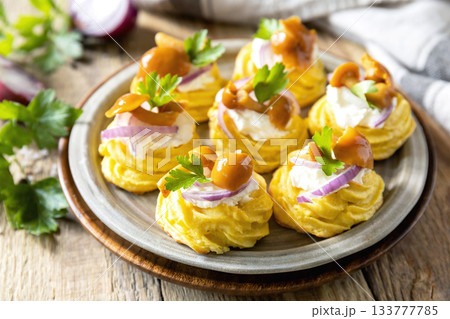 Potato tartlets filled with cottage cheese and marinated mushrooms on a rustic background. 133777785