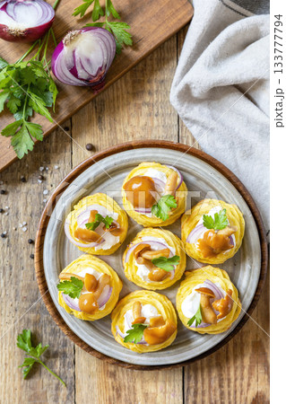 Potato tartlets filled with cottage cheese and marinated mushrooms on a rustic background. Top view. Potato tartlets filled with cottage cheese and marinated mushrooms on a rustic background. Top view. 133777794
