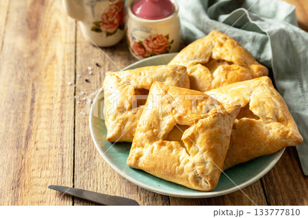 Puff pastry patties with mushroom and cheese filling on a rustic background. Copy space. 133777810