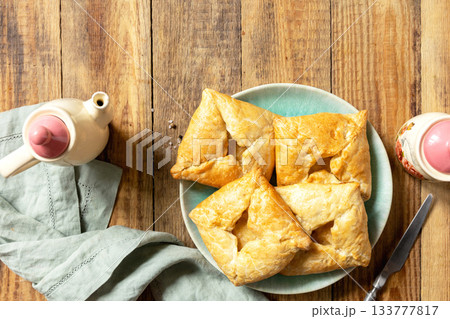 Puff pastry patties with mushroom and cheese filling on a rustic background. Top view. Puff pastry patties with mushroom and cheese filling on a rustic background. Top view. 133777817