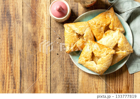 Puff pastry patties with mushroom and cheese filling on a rustic background. Top view. 133777819