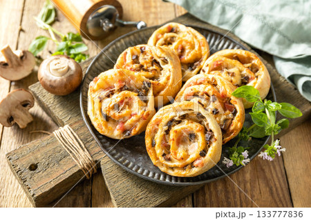 Puff pastry rolls with mushroom and cheese filling on rustic background. Puff pastry rolls with mushroom and cheese filling on rustic background. 133777836