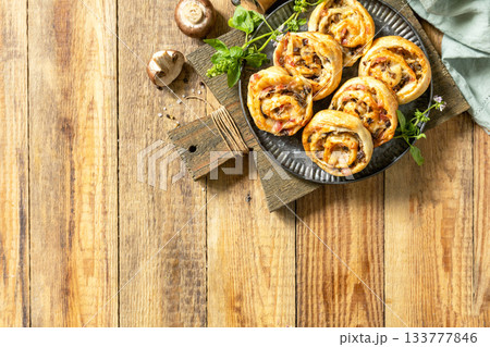 Puff pastry rolls with mushroom and cheese filling on rustic background. Top view. Puff pastry rolls with mushroom and cheese filling on rustic background. Top view. 133777846
