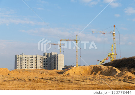 Several tower cranes stand tall over a large new high-rise residential development Several tower cranes stand tall over a large new high-rise residential development 133778444