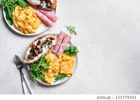 Healthy balanced breakfast with scrambled eggs, sandwich, ham Healthy balanced breakfast with scrambled eggs, sandwich, ham 133778501
