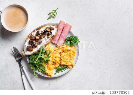 Healthy balanced breakfast with scrambled eggs, sandwich, ham 133778502