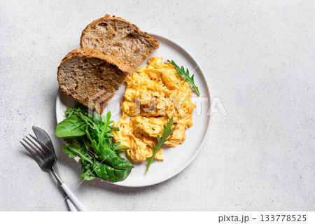 Scrambled eggs with greens for breakfast 133778525