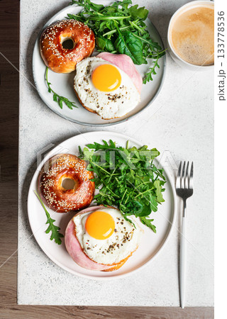 Healthy breakfast. Bagels with fried egg, ham and greens Healthy breakfast. Bagels with fried egg, ham and greens 133778536
