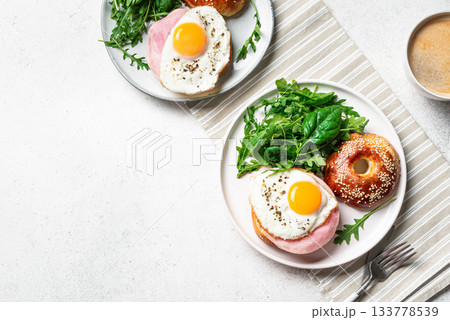 Healthy breakfast. Bagels with fried egg, ham and greens Healthy breakfast. Bagels with fried egg, ham and greens 133778539
