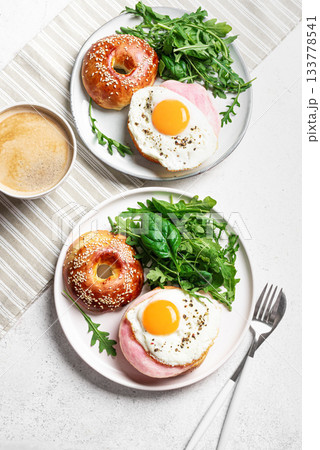 Healthy breakfast. Bagels with fried egg, ham and greens Healthy breakfast. Bagels with fried egg, ham and greens 133778541
