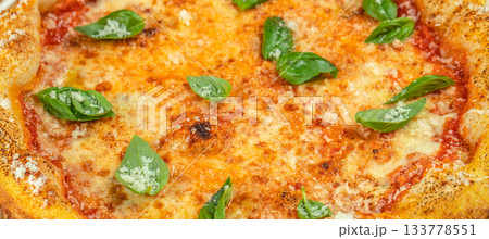 Freshly baked Margherita pizza with golden melted cheese, tomato sauce, and vibrant basil leaves, captured in a delicious close-up ideal for food menus, restaurant promotions, and culinary advertising 133778551
